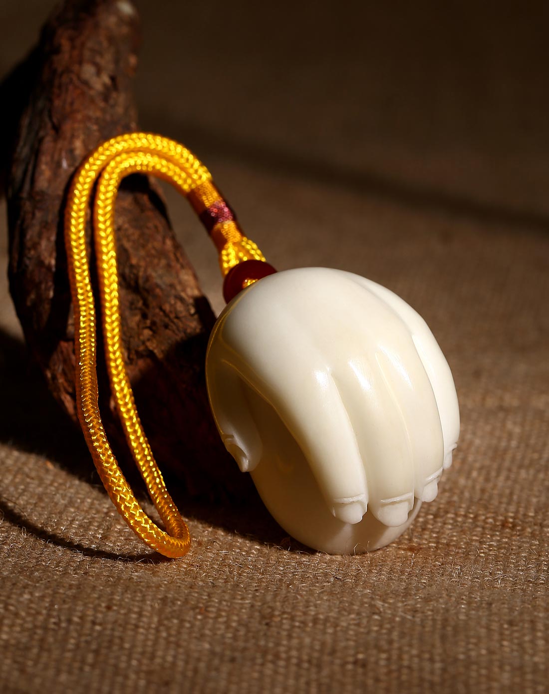 聚财在手象牙果手把件(元宝)